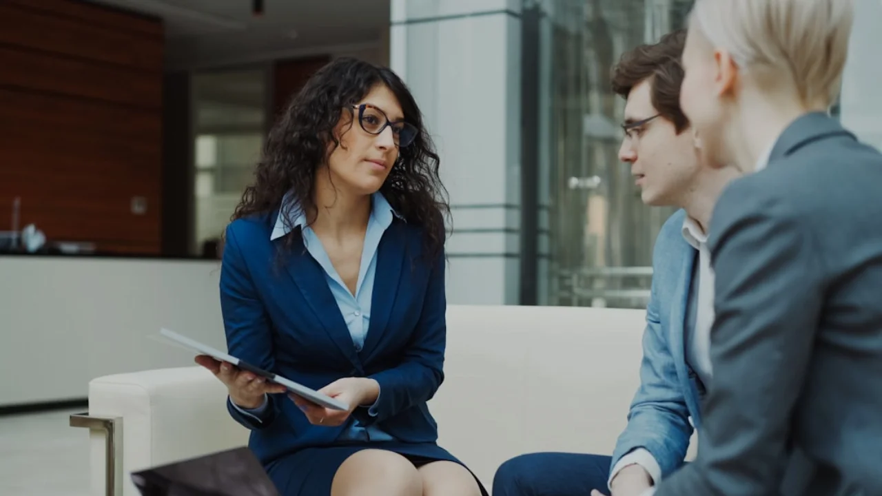 Three professionals in a business meeting discussion